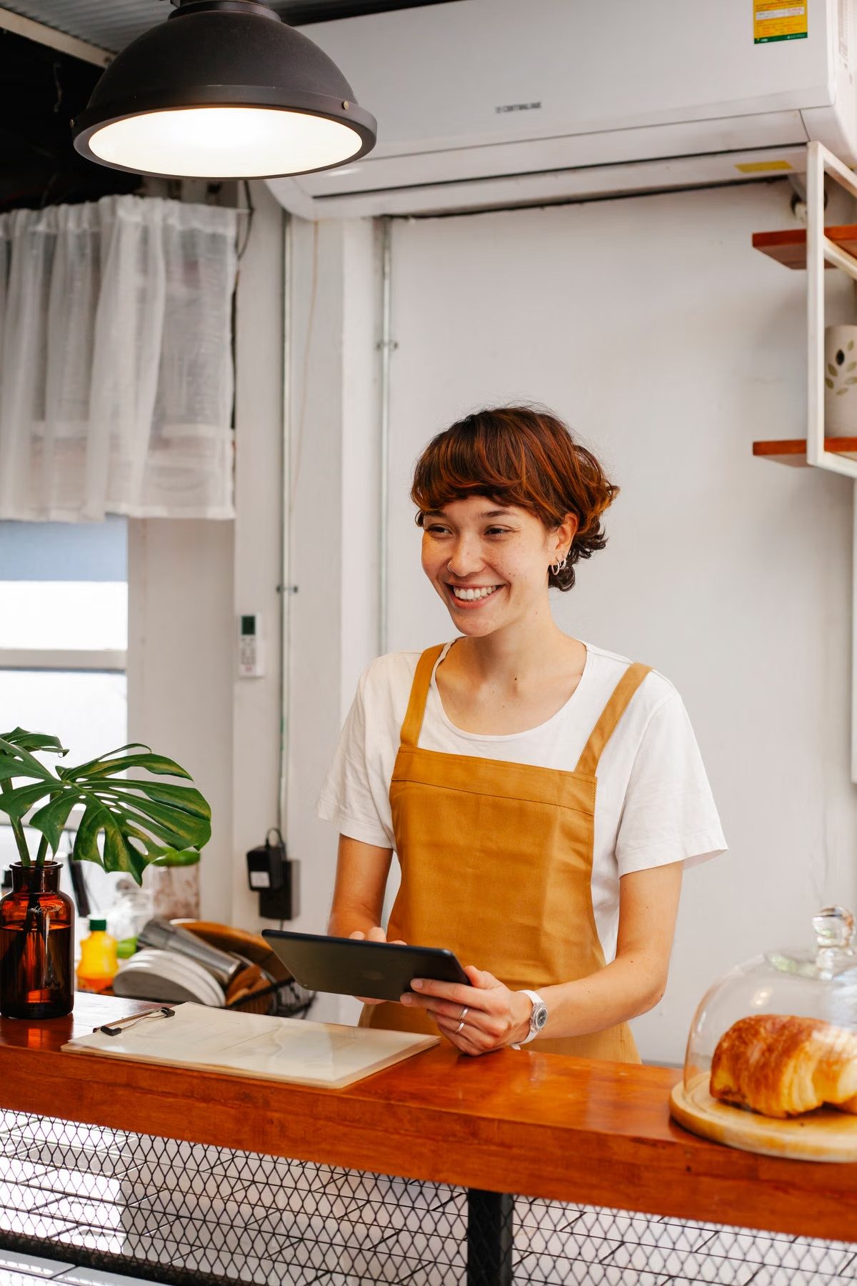 カフェのカウンターでタブレットを持つ店員